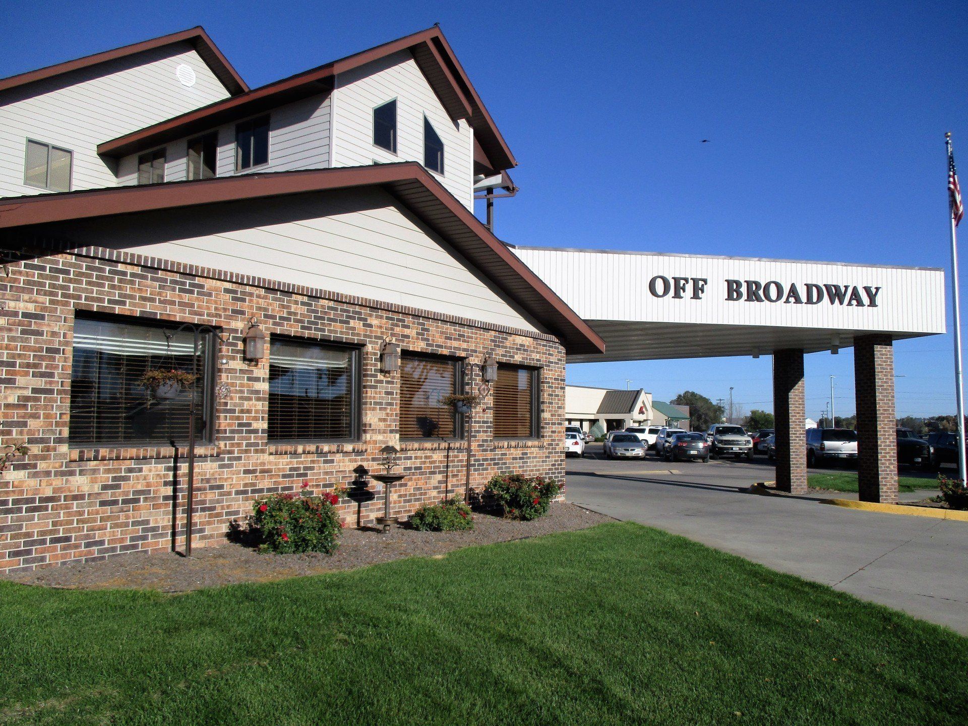 A brick building with a white sign that says off broadway