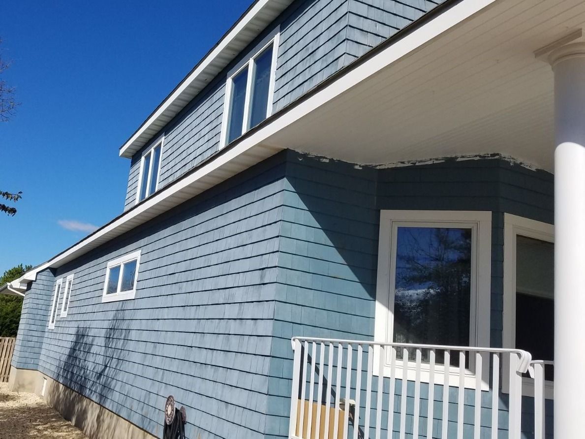 A blue house with a white railing and a balcony