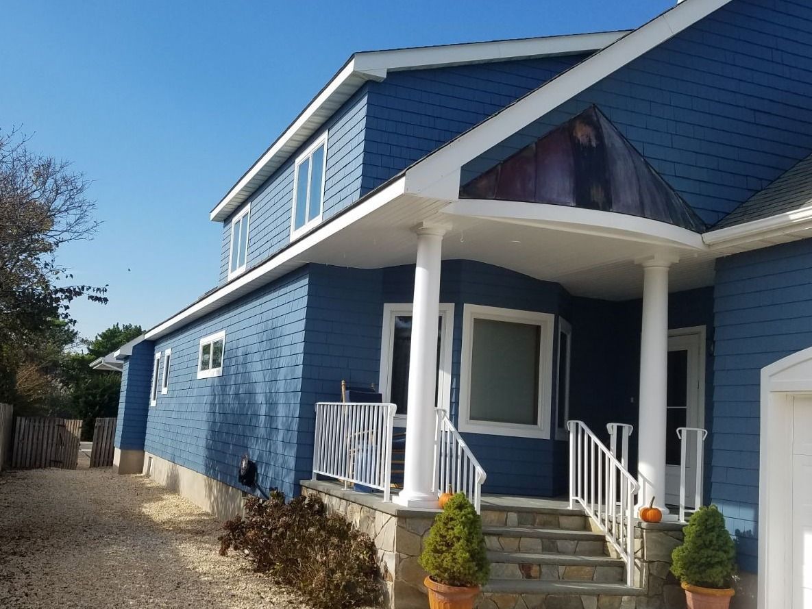 A blue house with a white porch and stairs