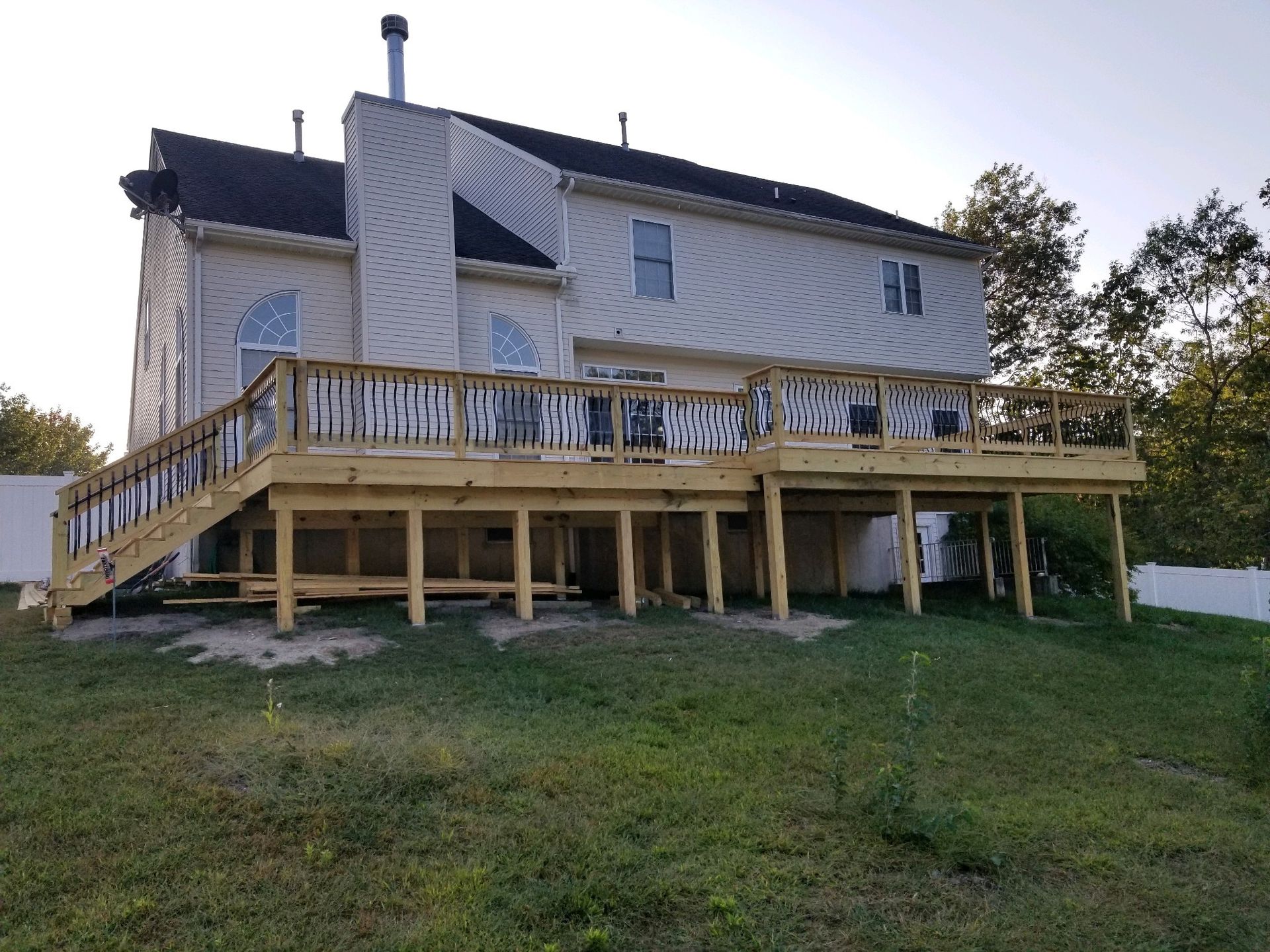 A large house with a large wooden deck in front of it.