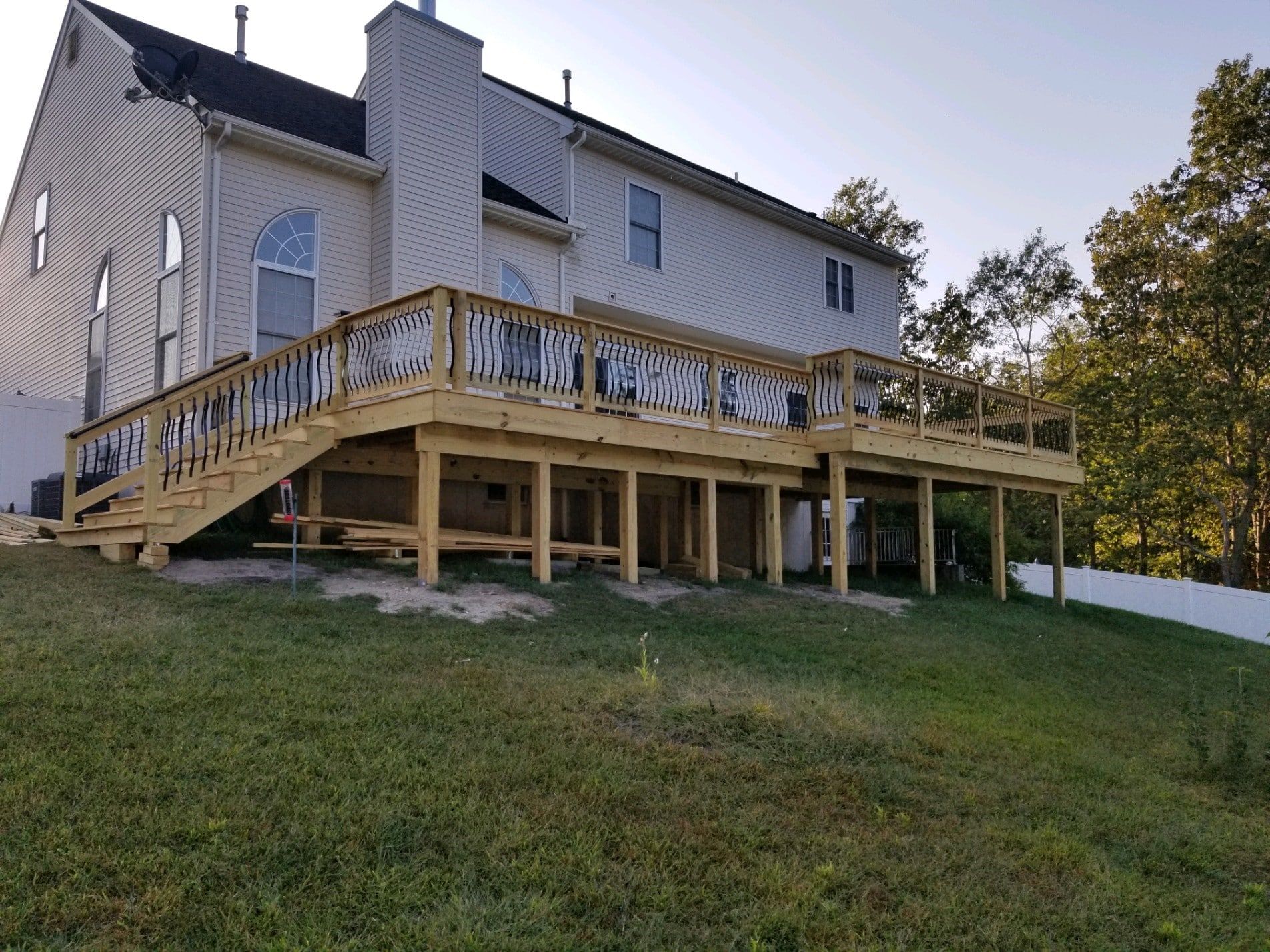 A large house with a large wooden deck in front of it.