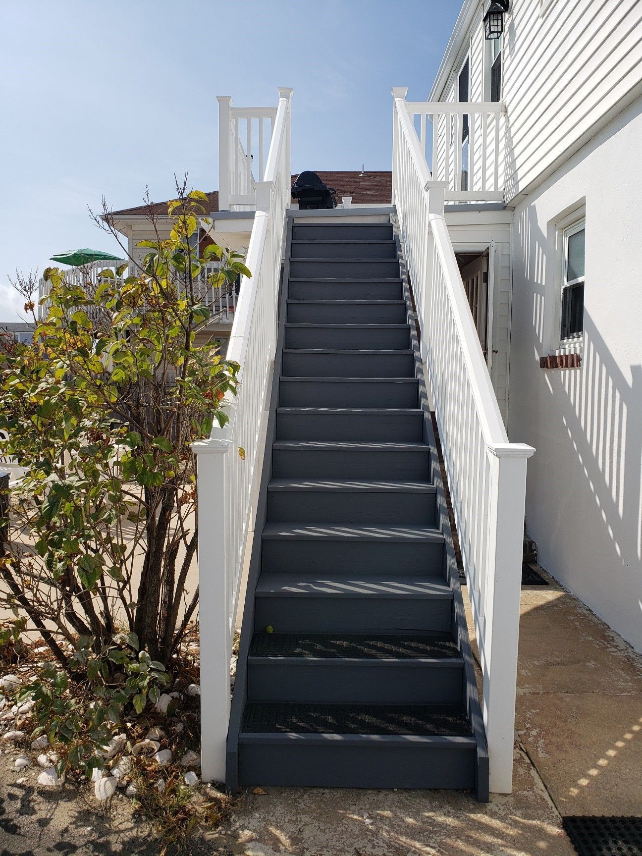 A set of stairs leading up to a deck on the side of a house.