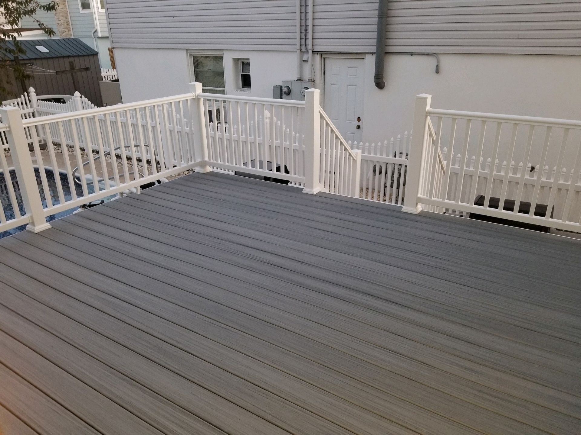 A deck with a white railing and stairs leading up to it.