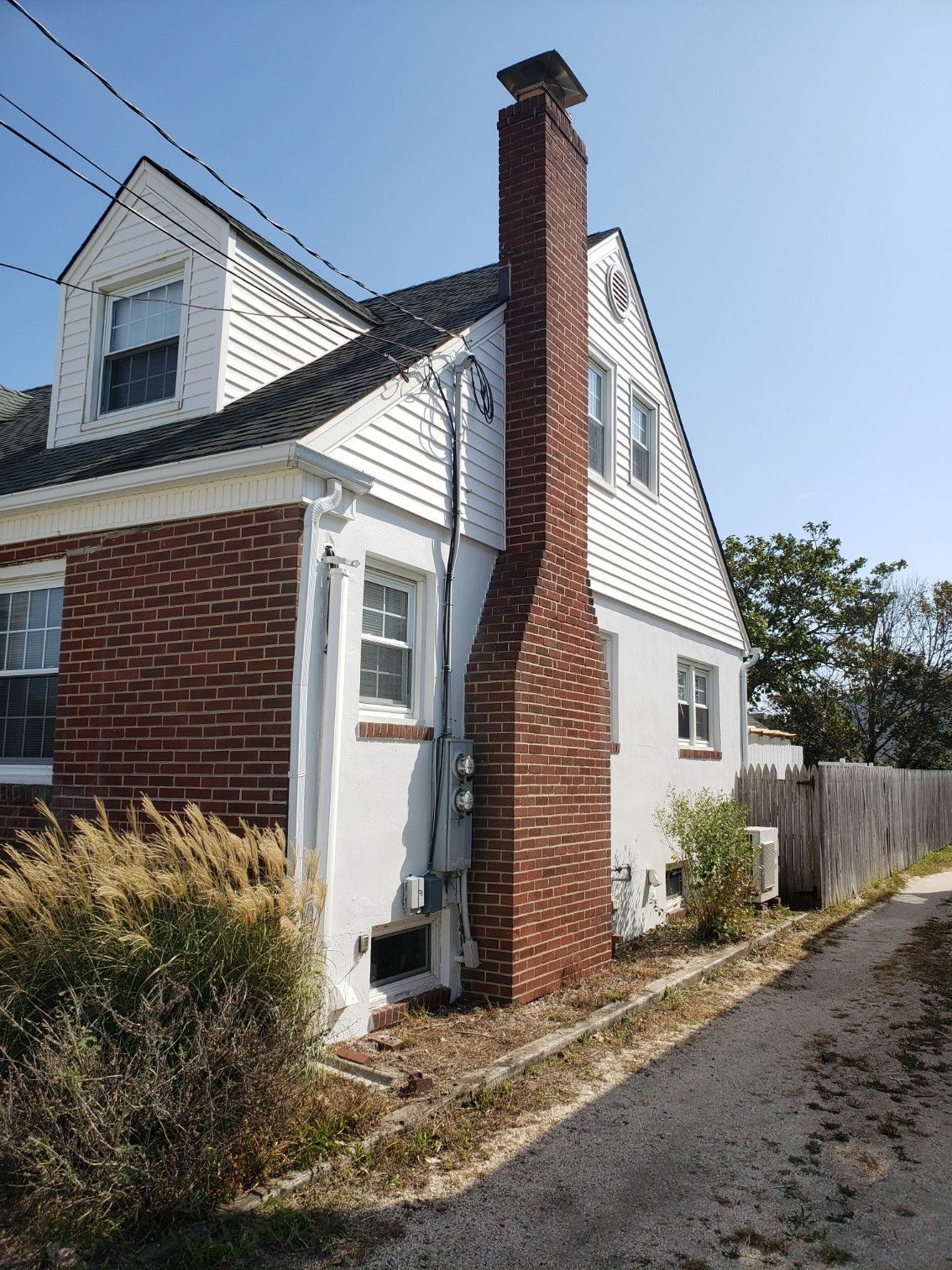A house with a brick chimney on the side of it.