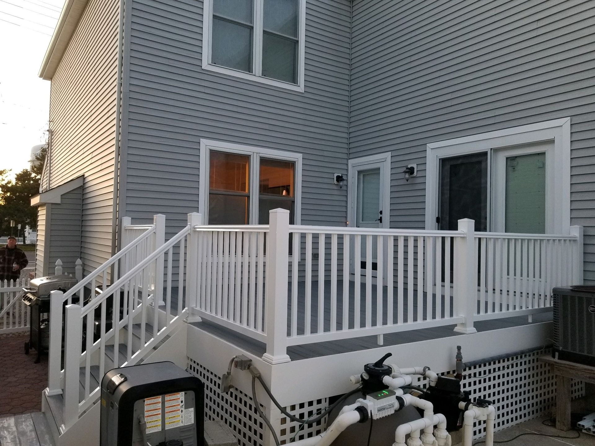 The back of a house with a white deck and stairs