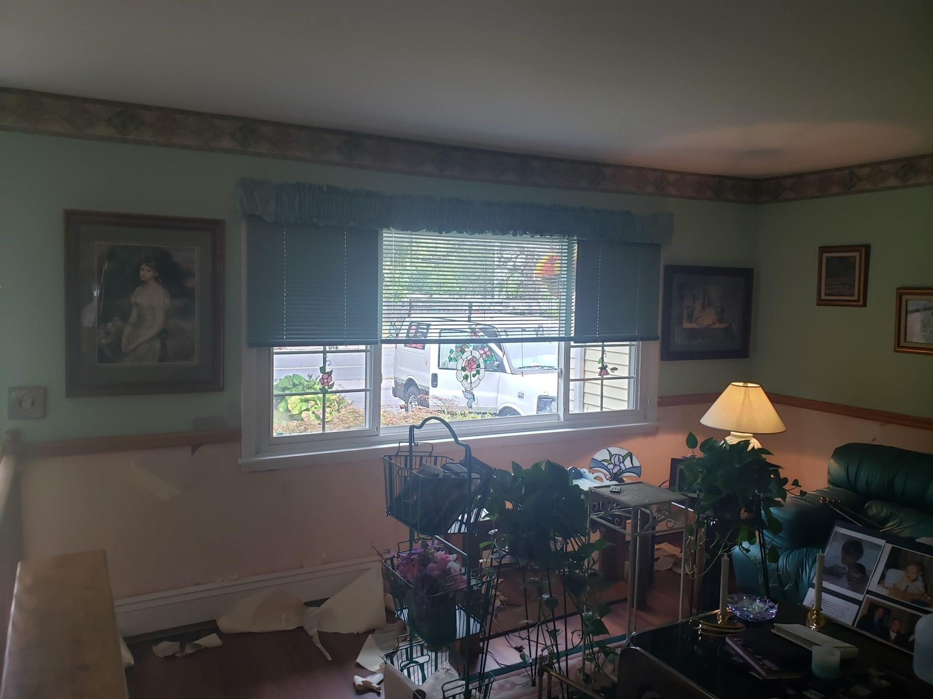 A living room with a green couch and a large window