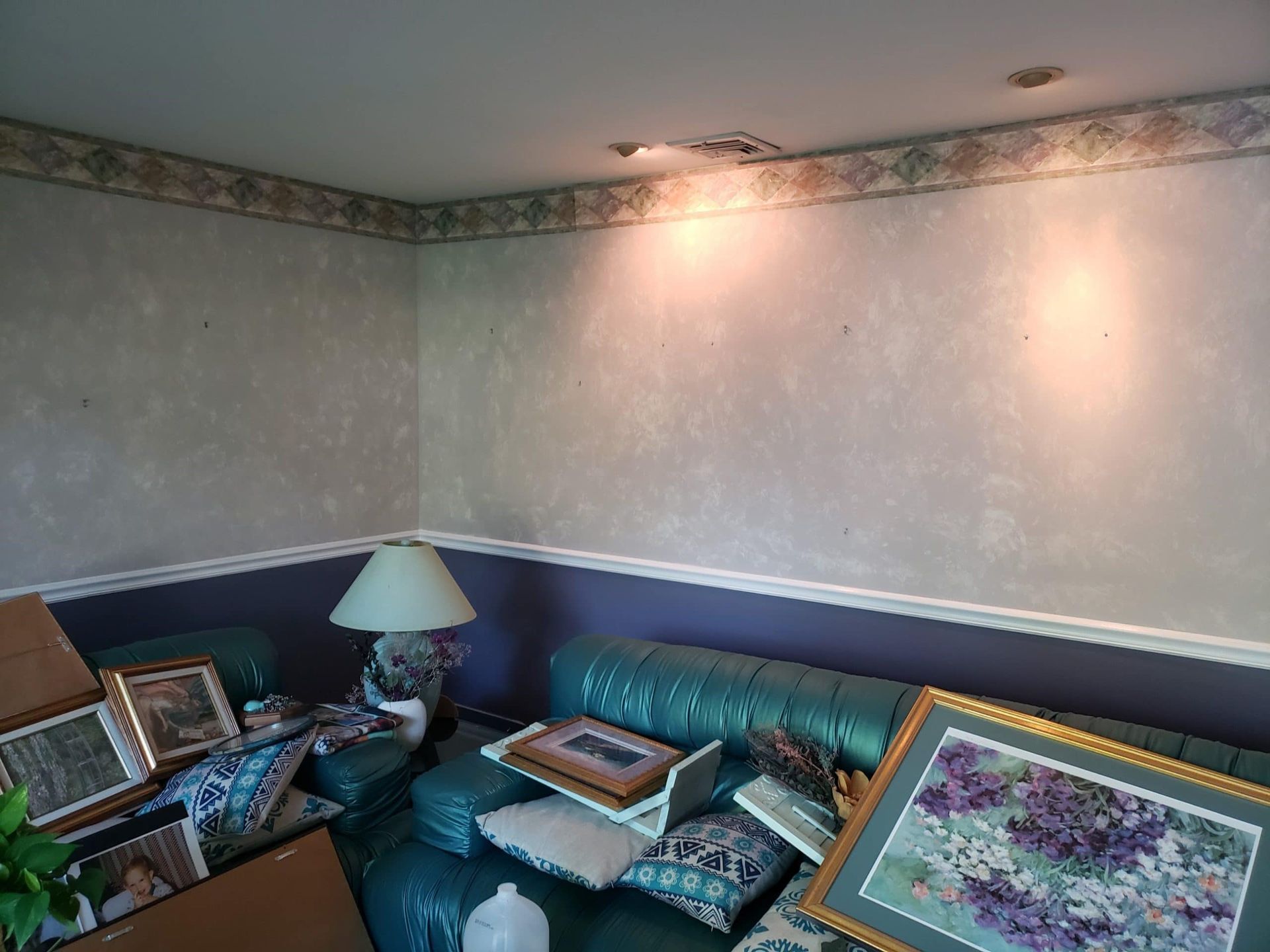 A living room with a green couch and purple walls