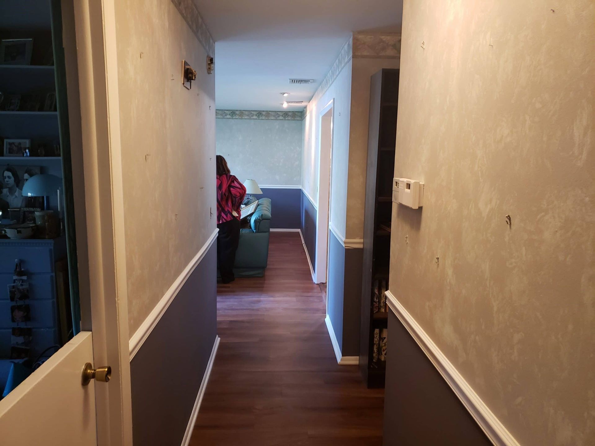 A long hallway leading to a living room and a dining room.