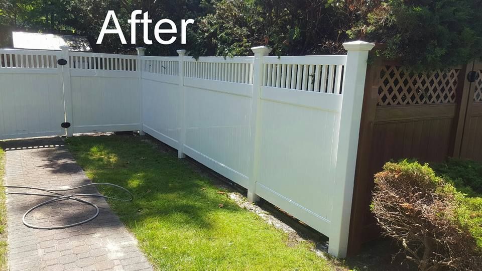 A white fence is sitting next to a brown fence in a yard.