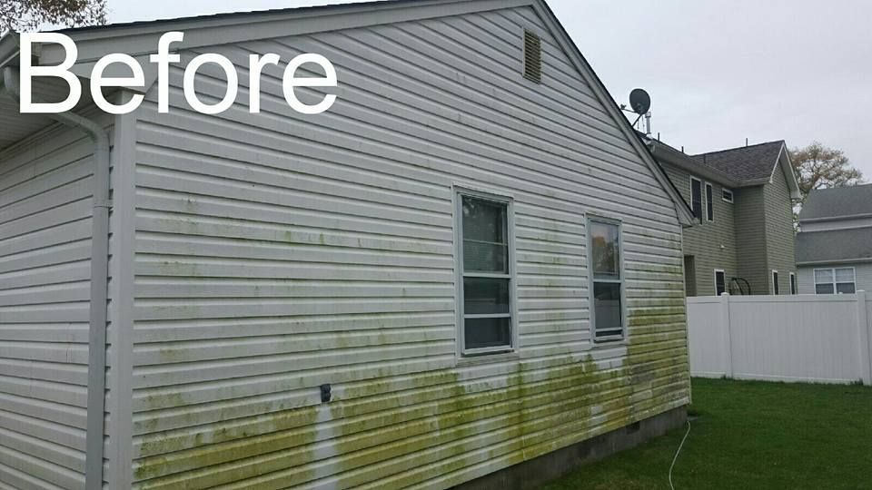A before picture of a house with green algae on the side.
