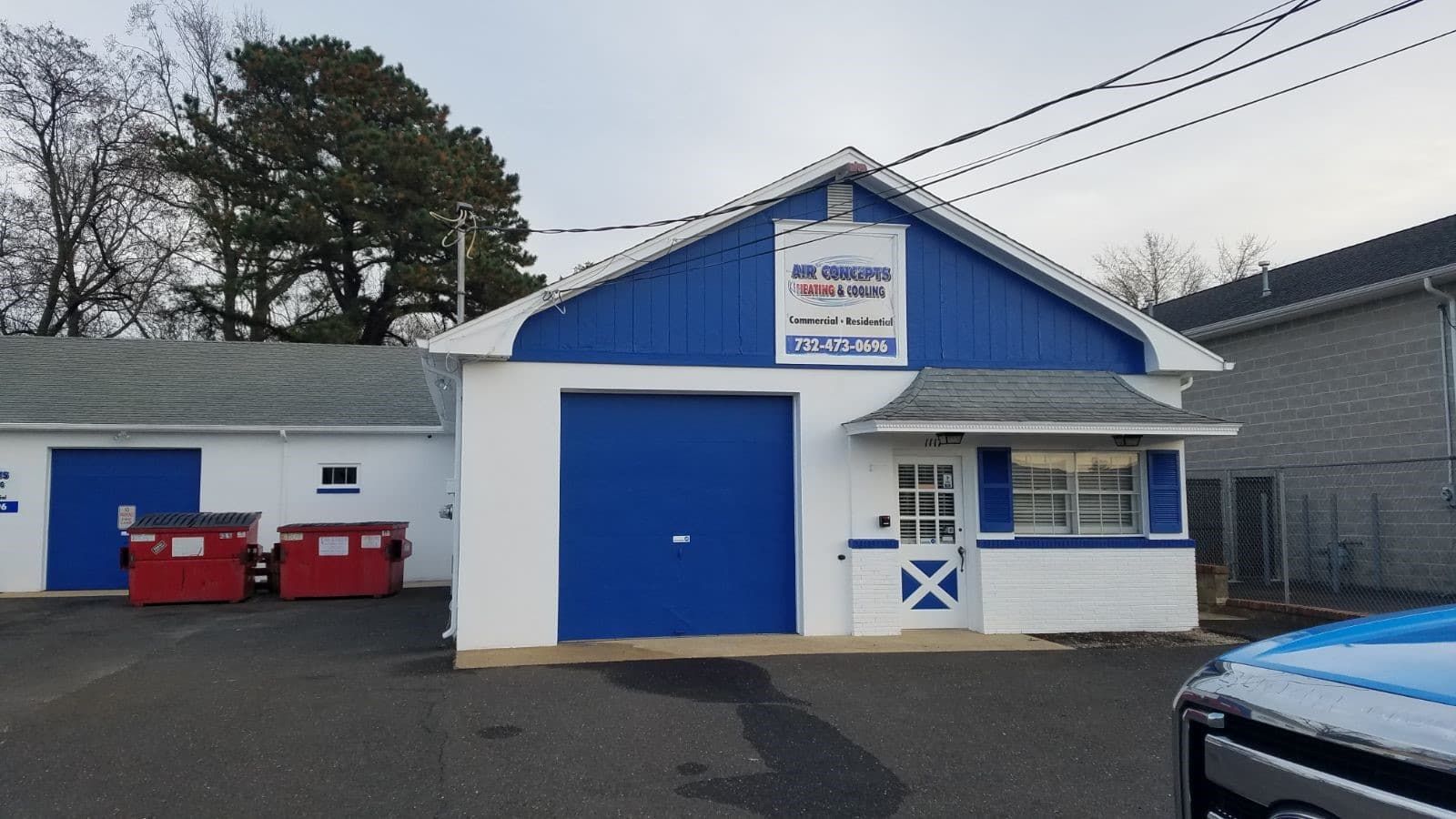 A white building with a blue roof and a sign that says drive in