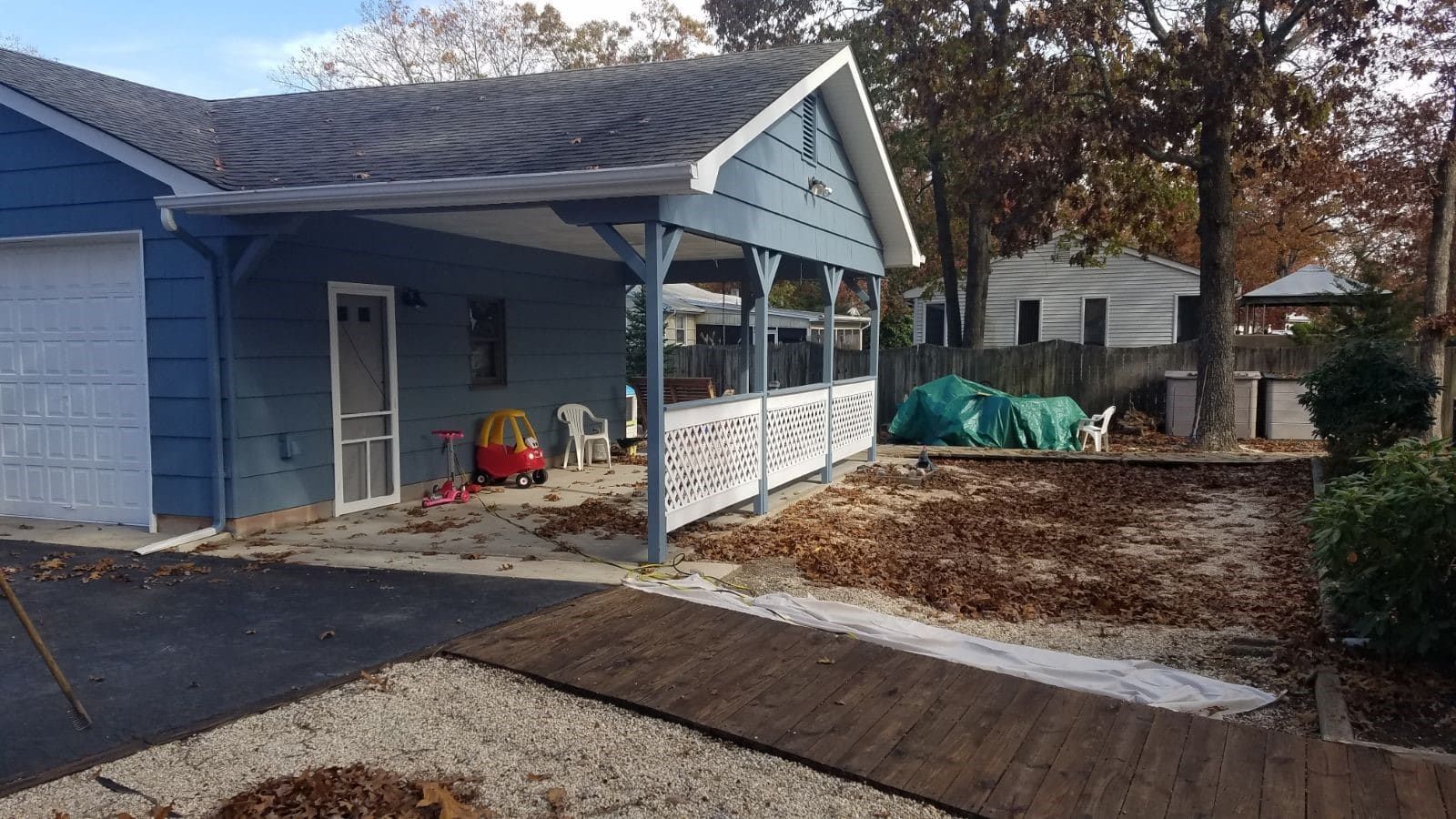 A blue house with a white garage door and a porch.
