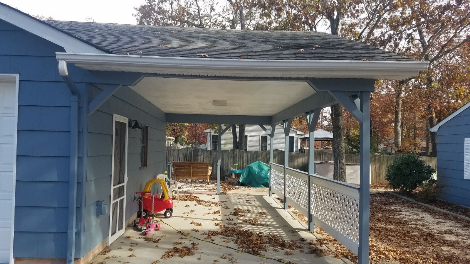 A blue house with a covered porch and a red wagon