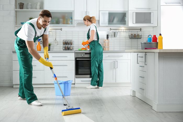 Man and woman cleaning the kitchen