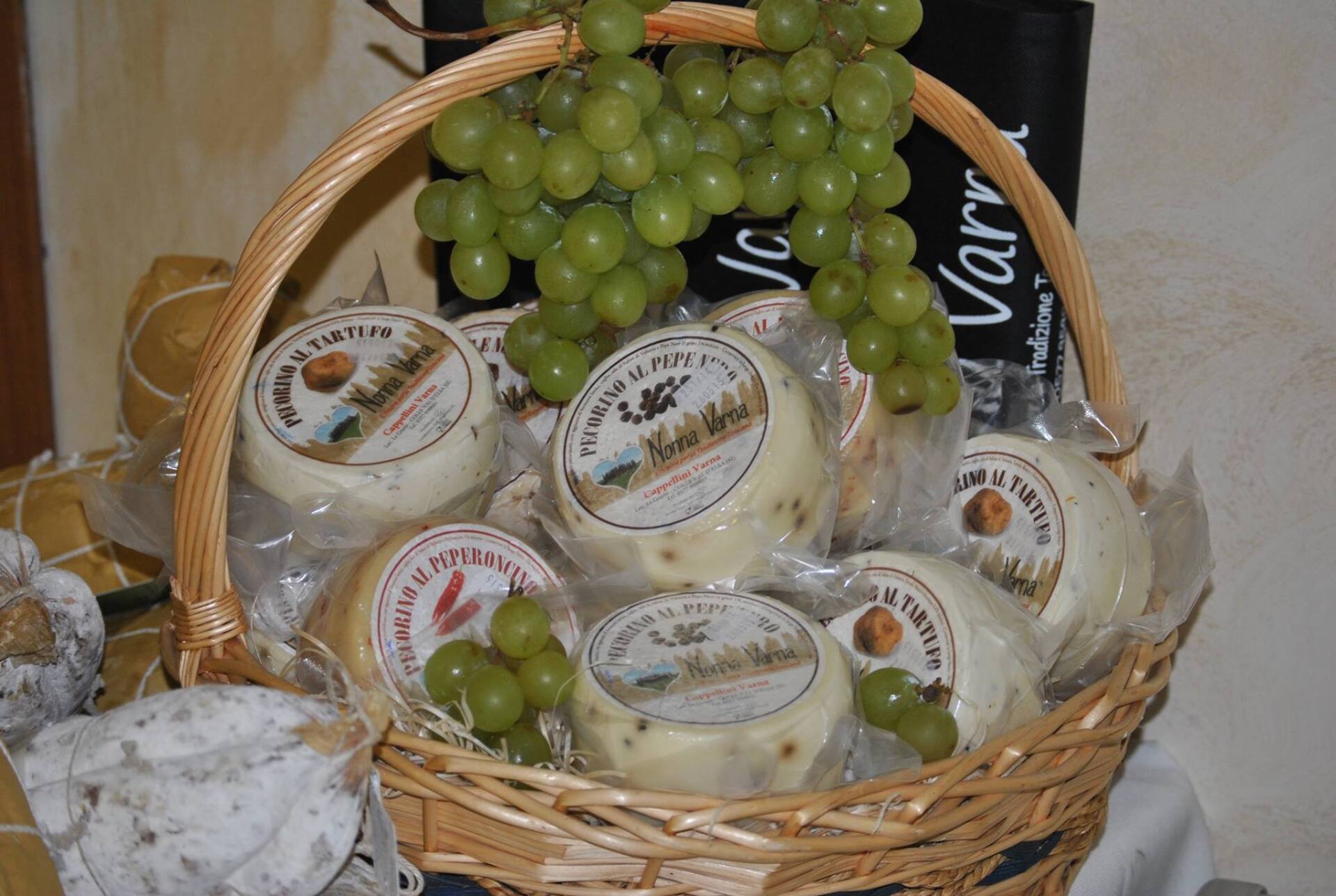 Cesto di formaggi a fette e uva.