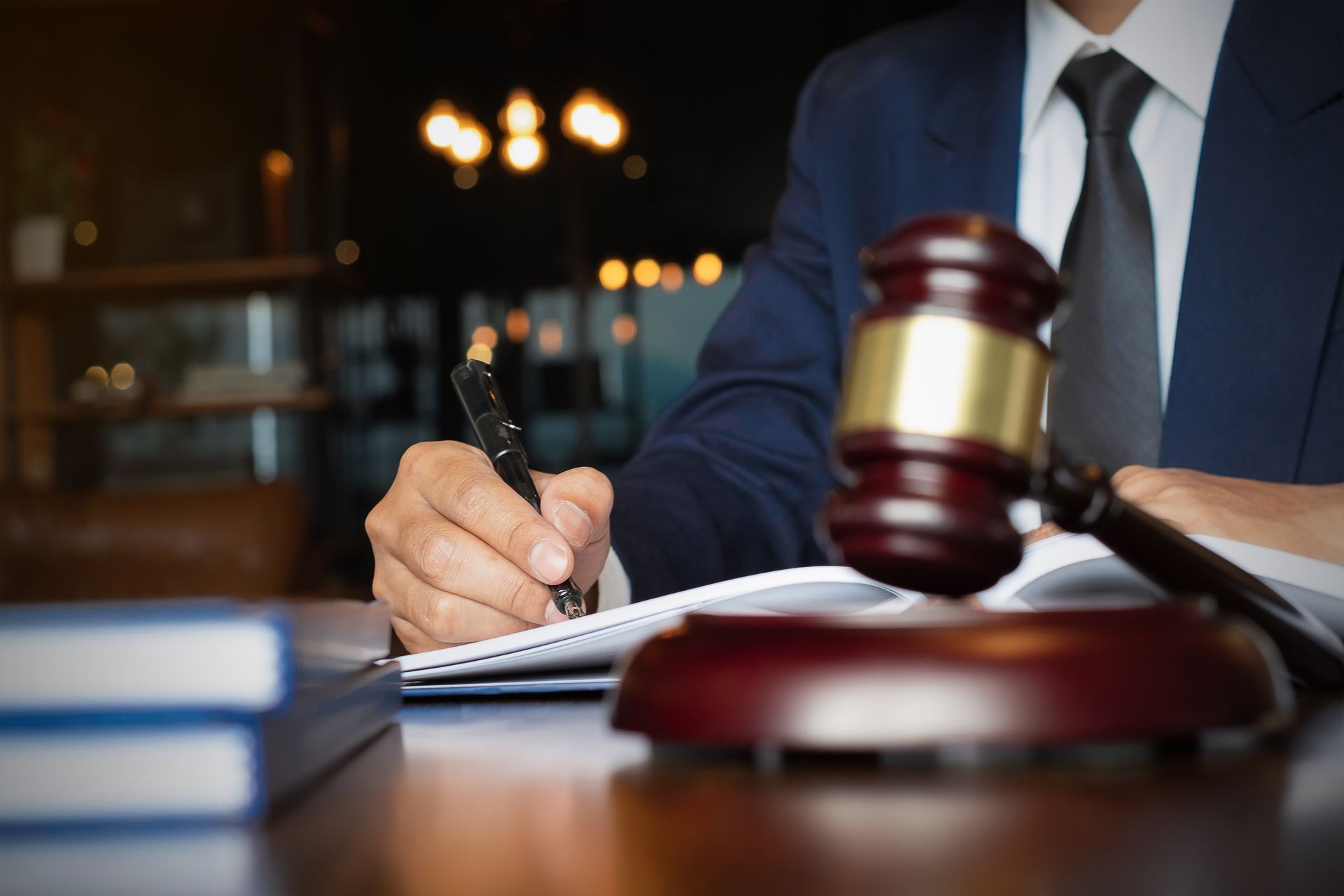 A lawyer reads a law book at a desk in an office workspace. A lawyer reads a law book at a desk in an office workspace.