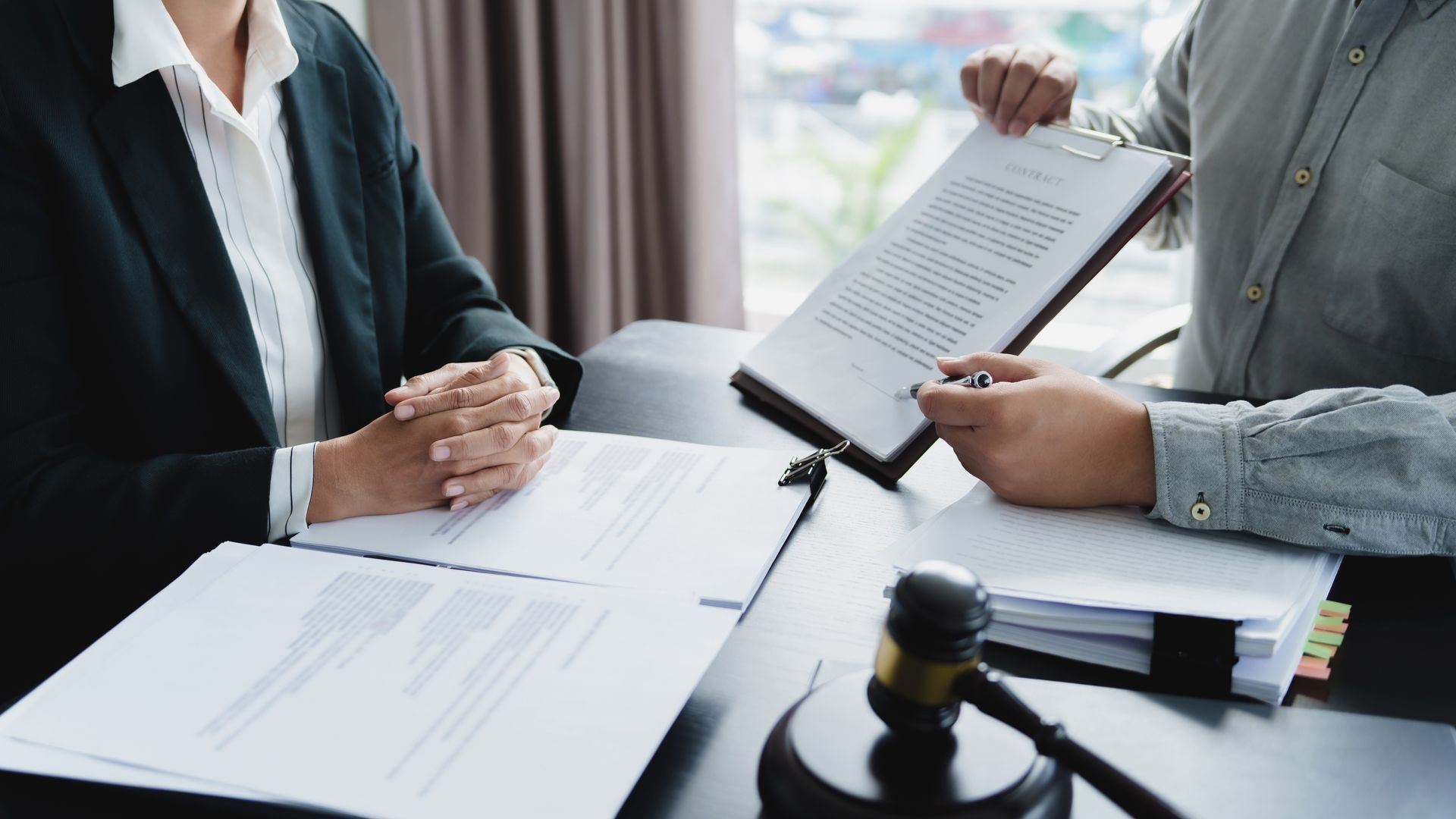 Attorney reviewing legal documents and explaining contract terms to a client Attorney reviewing legal documents and explaining contract terms to a client