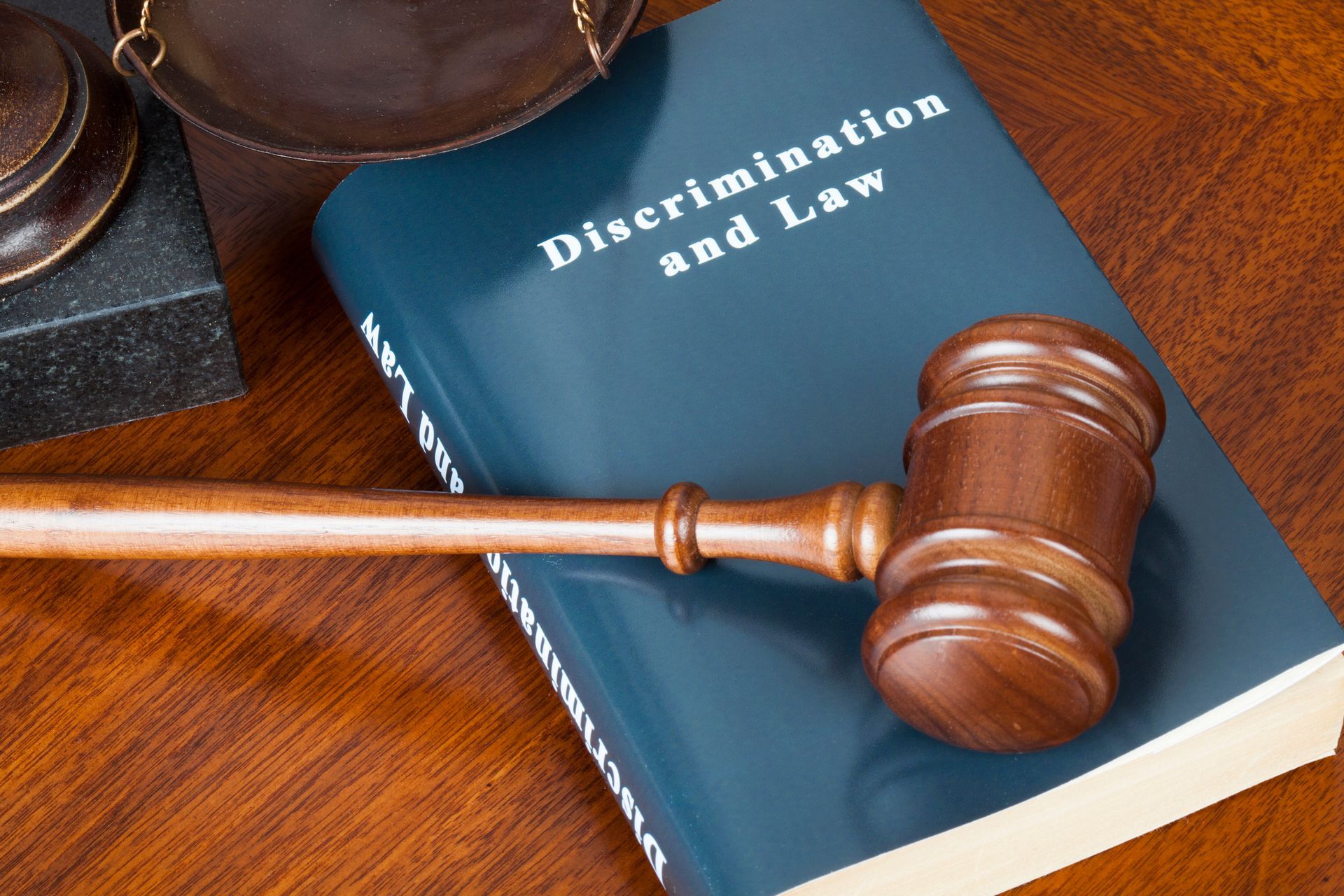 Wooden gavel resting on a discrimination law book, symbolizing justice and fairness.