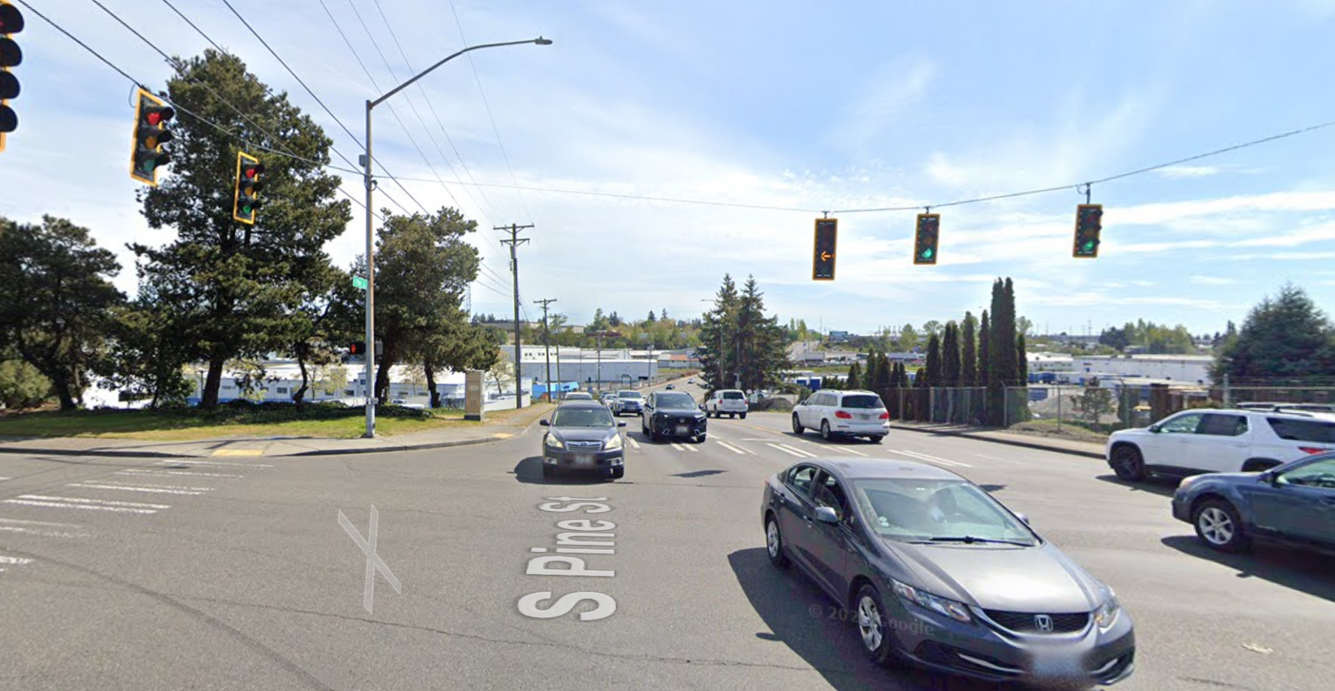 Busy street intersection with cars waiting at a traffic light on a sunny day