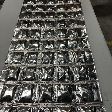 Silver rectangular packaging composed of numerous small, sealed pouches.