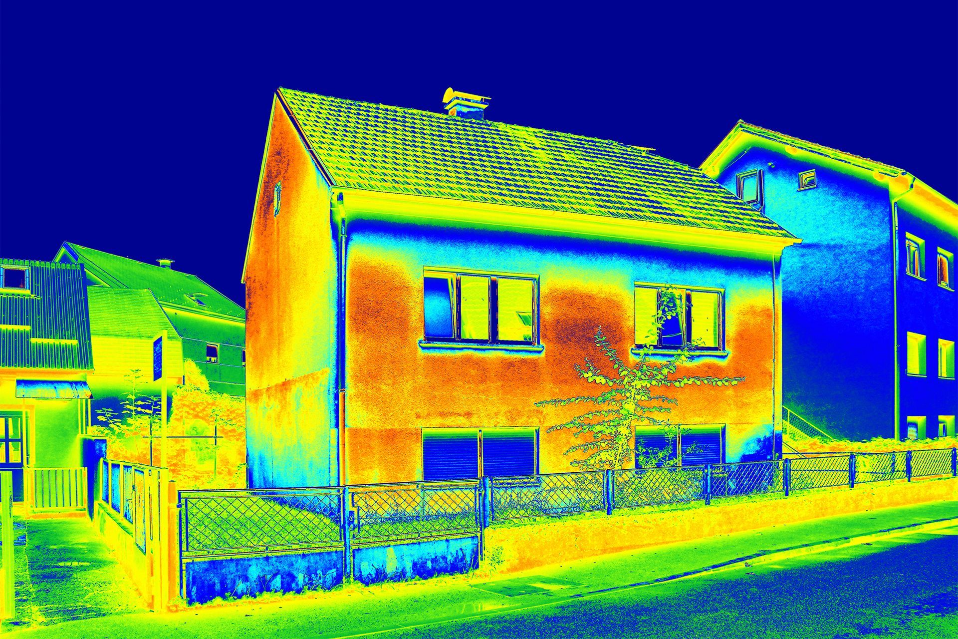 Thermal image of a house showing heat loss. Warmer colors (red, orange, yellow) indicate areas of greater heat.