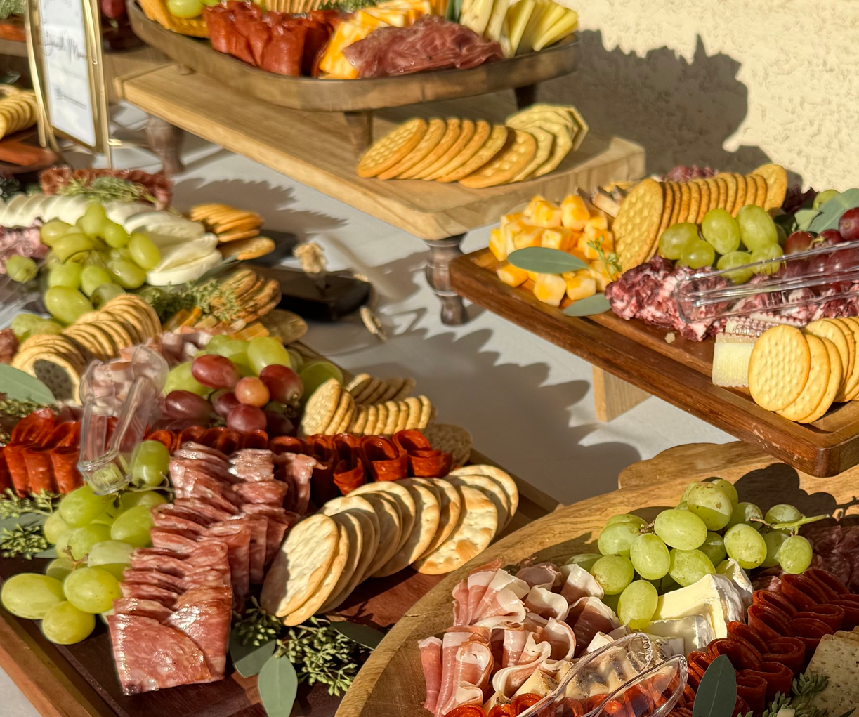 A table with a vase of flowers and a tray of food on it.