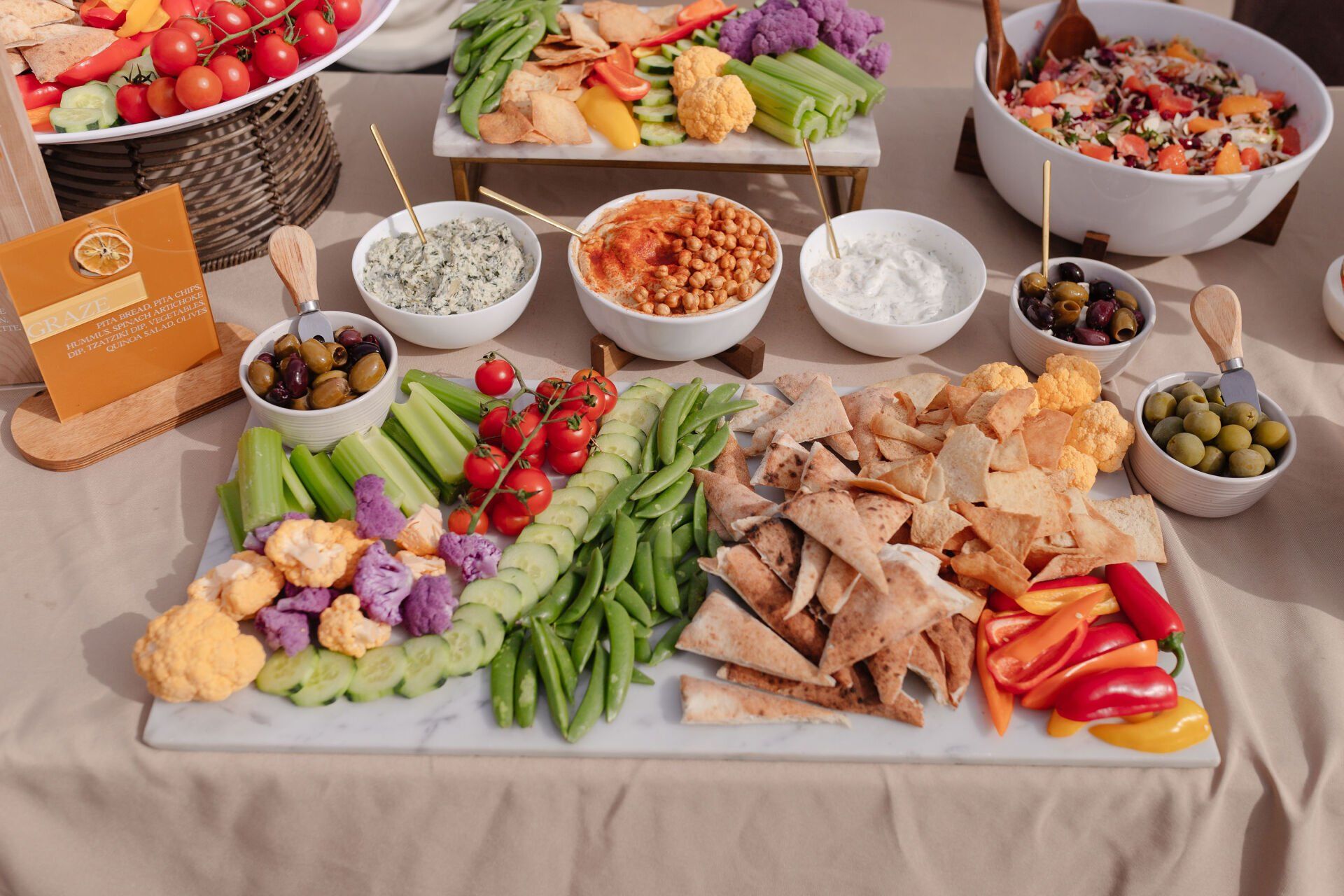 A table topped with a variety of vegetables and dips for Beyond Basil Mobile Pizzeria.