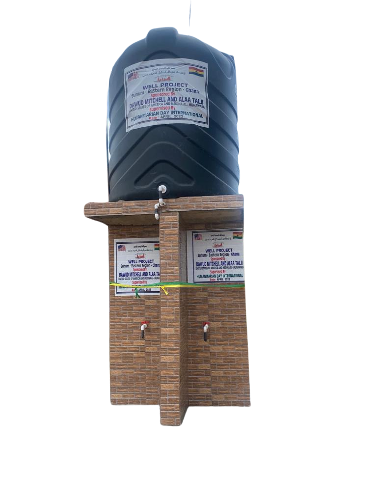 A black water tank is sitting on top of a brick wall.