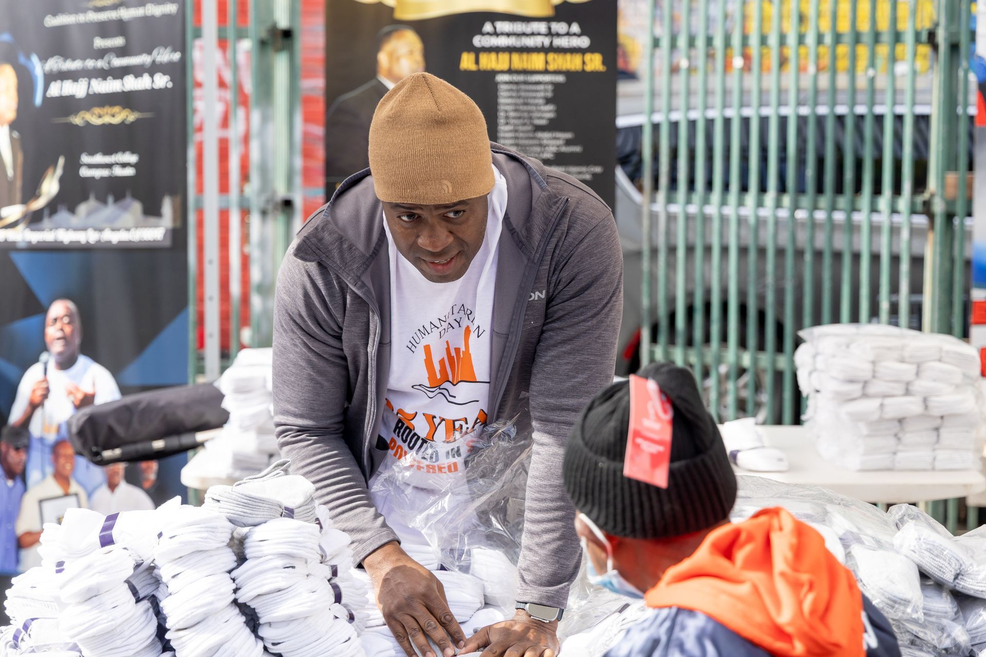 Man distributing face masks at an outdoor event. Another person is present.