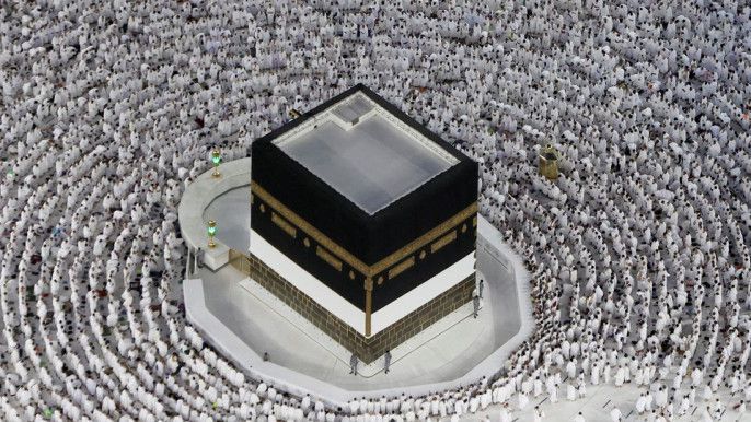 Kaaba in Mecca, surrounded by circling Muslim pilgrims, white garments.