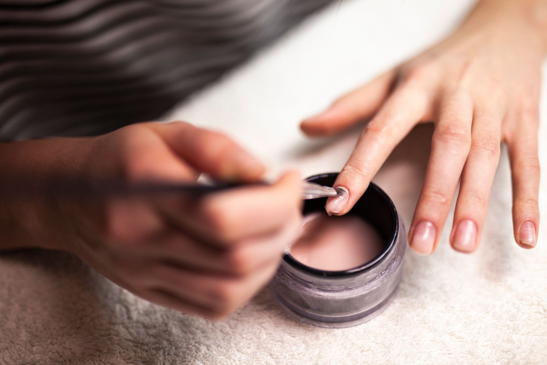 A woman is getting her nails painted at a nail salon.