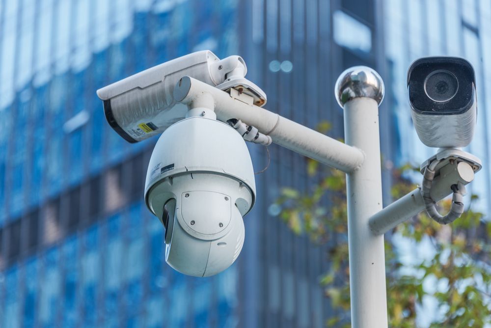 A Security Camera is Sitting on Top of a Pole in Front of a Building — Cambush Security Solutions NT in Palmerston, NT
