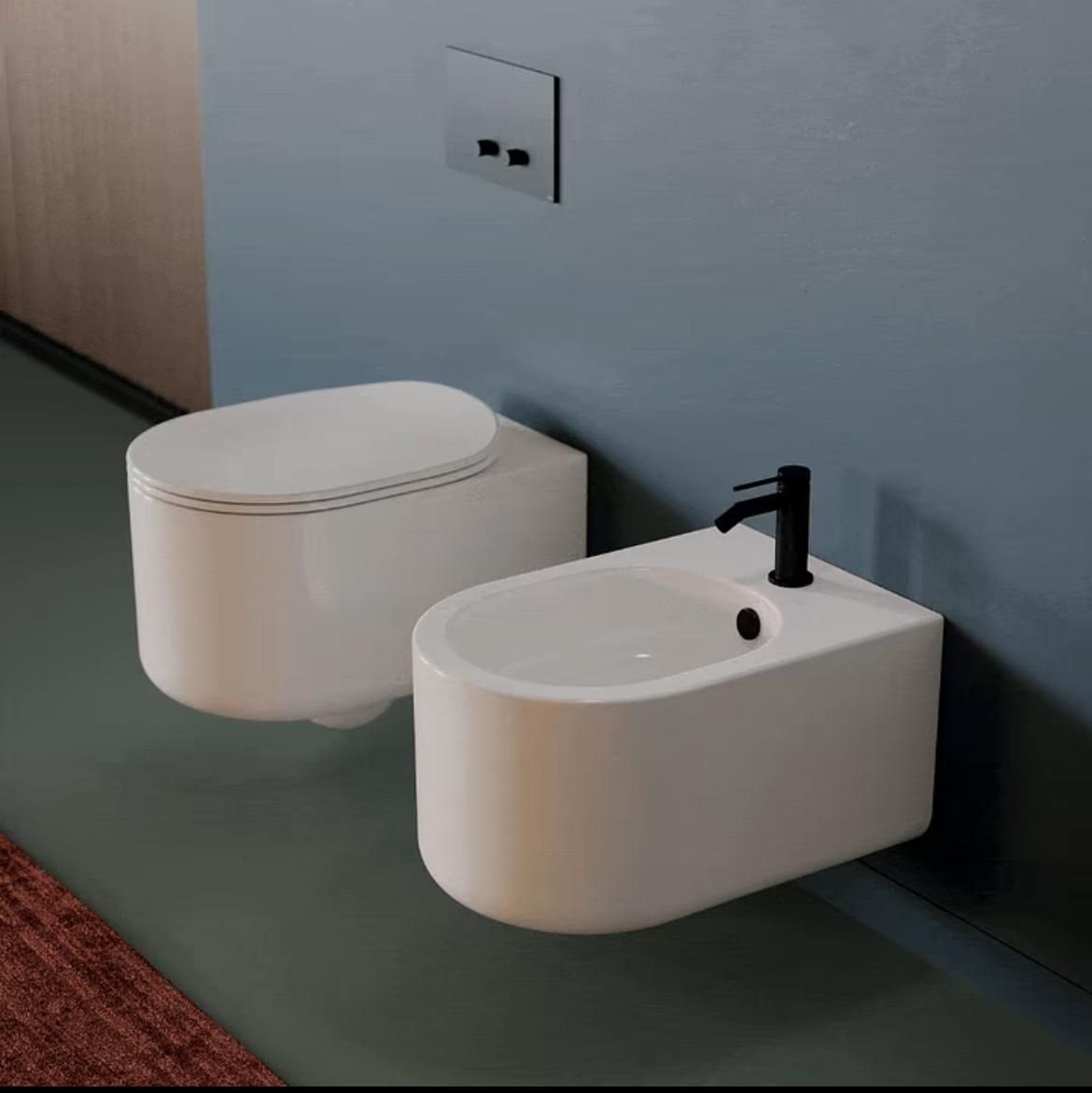 Bagno moderno con WC bianco e bidet abbinato su una parete blu, rubinetto nero e rivestimento in legno.