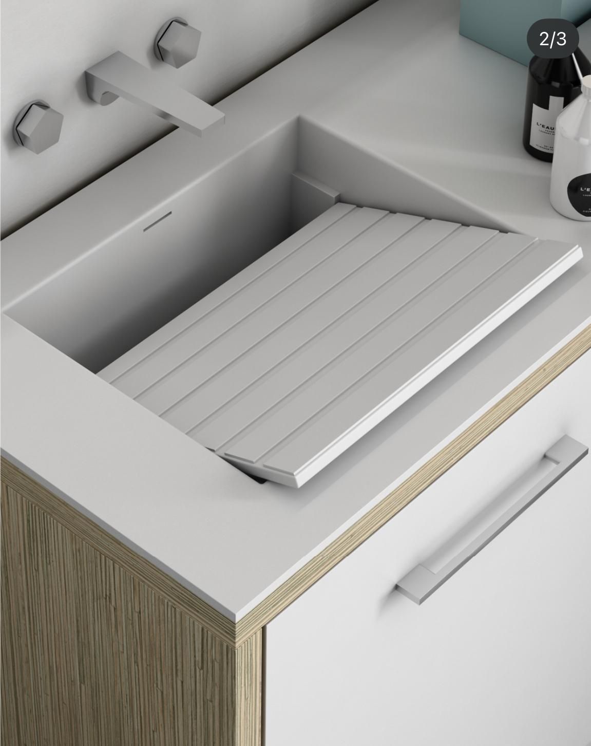 Lavabo bianco da bagno con scolapiatti e dispenser di sapone sul piano.