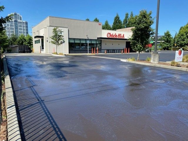 Parking Lots Pavement — Worker Holding A Shovel With Paving Machine In Kent, WA