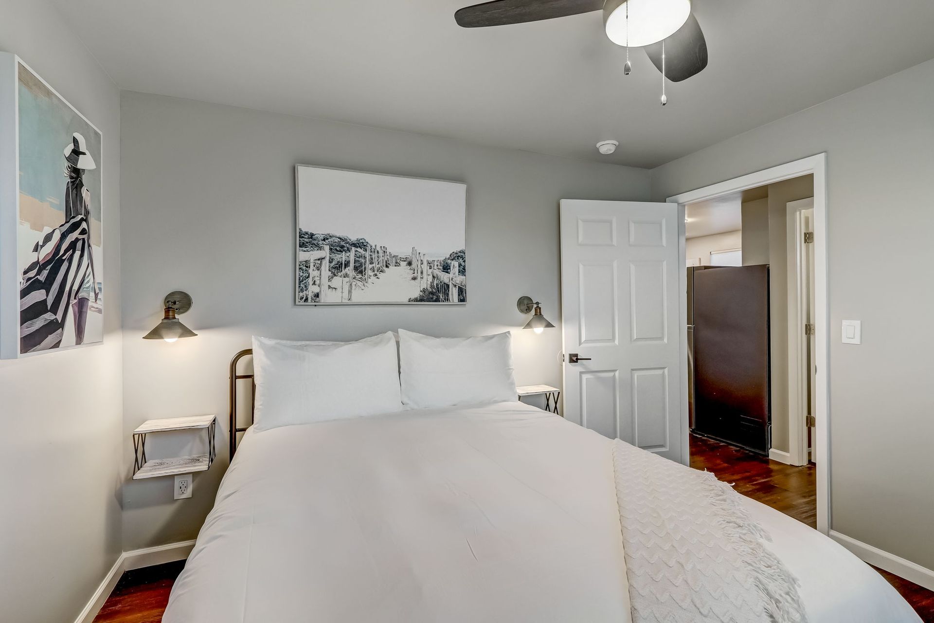 A bedroom with a queen size bed, Stearns and Foster mattress, mini split air conditioning unit and a ceiling fan.