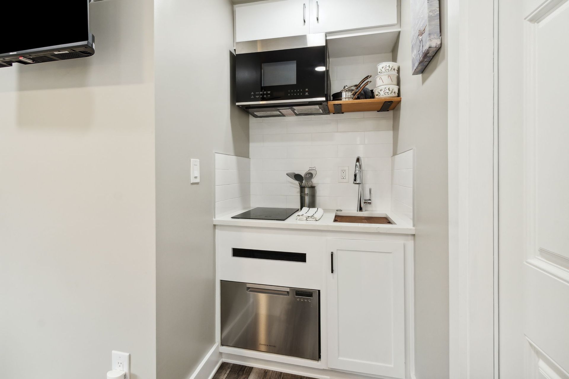 A small kitchen with a sink , microwave , and dishwasher.