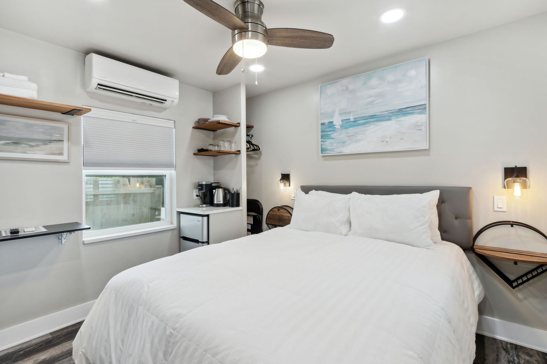 A bedroom with a bed , ceiling fan , and window.