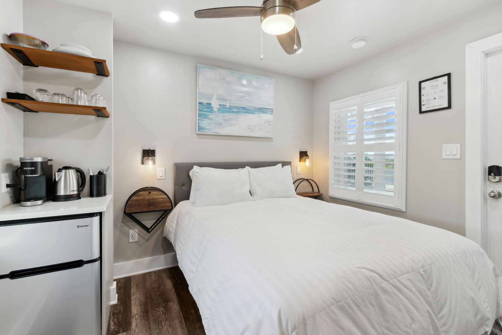 A bedroom with a king size bed and a ceiling fan.