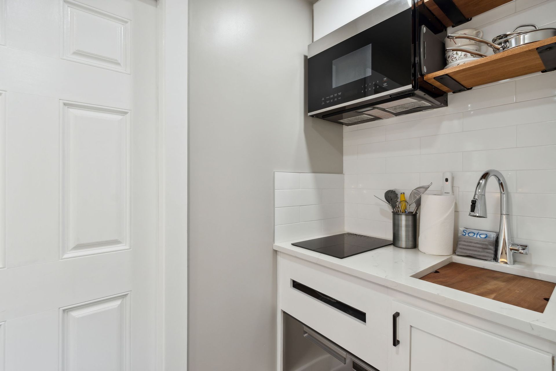 A kitchen with a sink , microwave , and stove.