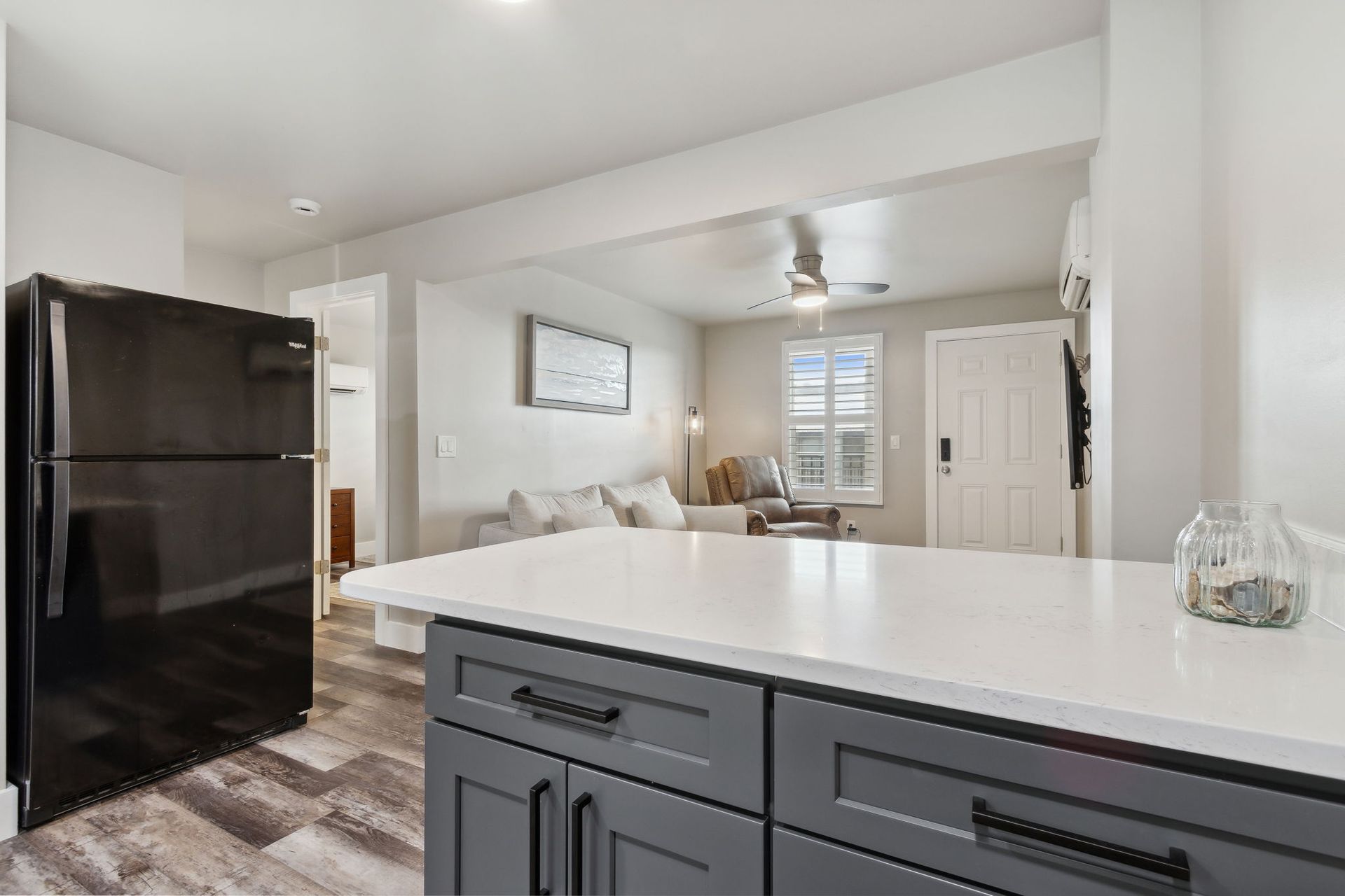 A kitchen with a black refrigerator and a white counter top.