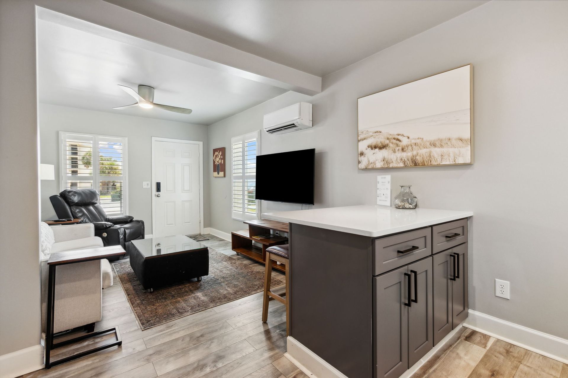 A living room with a flat screen tv and a painting on the wall.