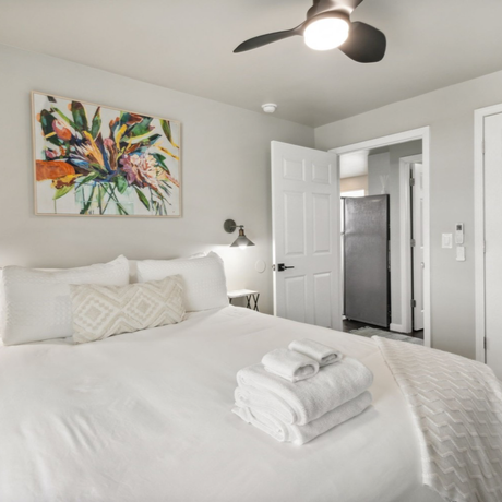 A bedroom with a large bed and a ceiling fan