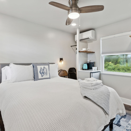 A bedroom with a large bed and a ceiling fan