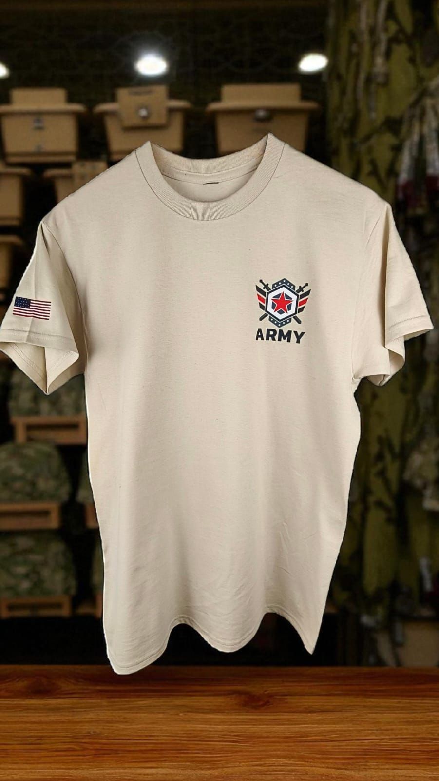Camiseta beige con el dibujo de unas botas oscuras sobre una bandera estadounidense, colgada en una tienda rústica.