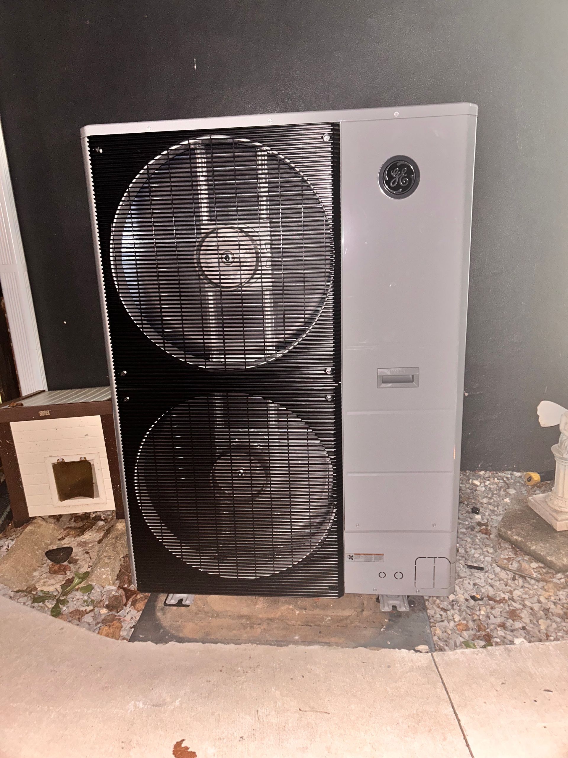 Standing air conditioner unit with two large black vents against a gray wall.