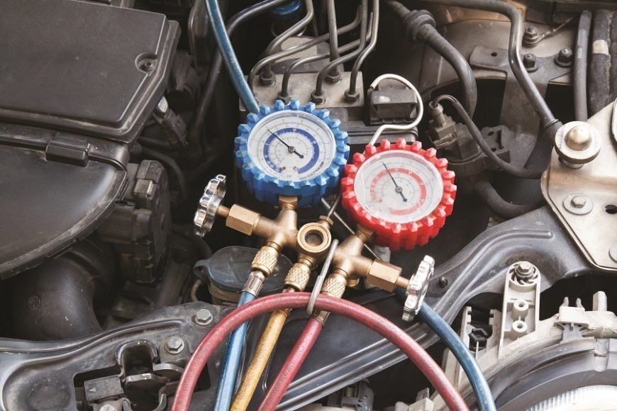 A close up of a car engine with two gauges on it