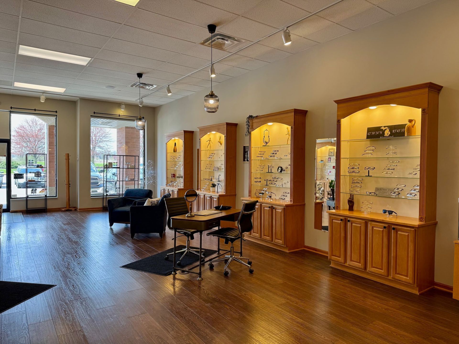 A large room with wooden floors and lots of shelves and cabinets.
