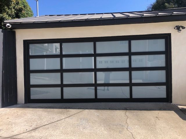 Garage with black frame and frosted glass panels; exterior view.