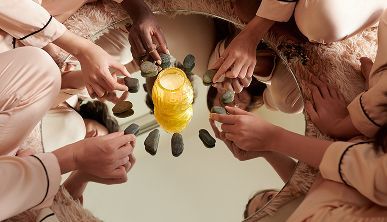 A group of people are sitting in a circle holding rocks.